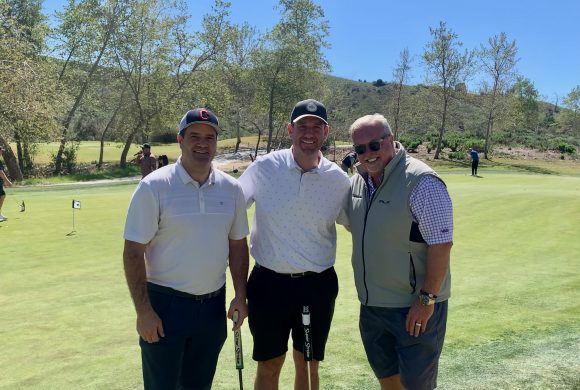 Three men smiling on a golf course