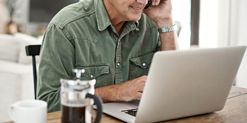 Elderly man working on laptop