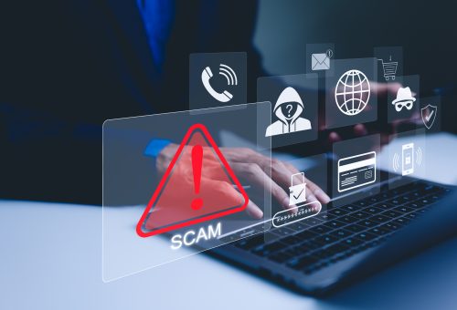 Scam Alert Warning with Cybersecurity Icons. A person using laptop, warning sign for scams with icons representing online threats, phishing, and cybersecurity. Unknown person, suspicious scammer,